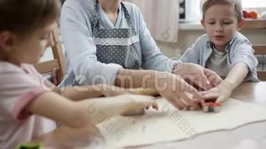 妈妈展示如何用正确的方法制作饼干，并帮助她的儿子