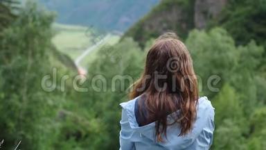 <strong>梦中的</strong>女孩坐在群山<strong>的</strong>背景上，头发飞扬。 回头看。 慢动作
