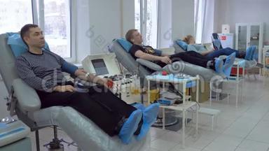 三名献血者在输血中心献血。