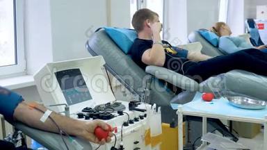 志愿者在现代中心献血，医疗机器在工作。