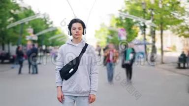十几岁的男孩在城市里用耳机听音乐