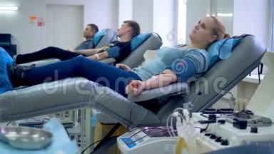 志愿者准备在一个特殊的中心献血，坐在扶手椅上。