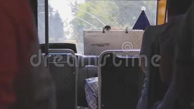 普通公共汽车的内景。 挡风玻璃后面的景观变化.. 人们坐在乘客座位上。 通道之间