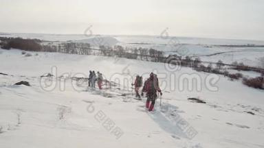 在滑雪杆的帮助下，一个陡峭的雪坡沿着一群登山者往下滑，他们<strong>轻轻地</strong>在滑雪道<strong>上</strong>留下一条小径
