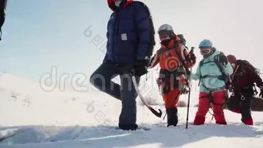 男女探险队在大雪中一个接一个地进行，女孩们用滑雪杆帮助自己。 在美国