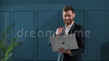 商人在笔记本电脑上工作。 他在国际上赢得了大合同. 他`很高兴。