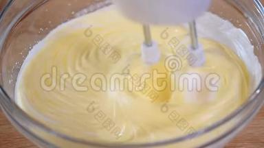 用电动搅拌器搅拌奶油。 家庭面包店。 家里烘焙的原料。 用手搅拌器打鸡蛋。