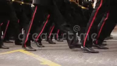 在游行队伍中行进的军人脚的特写。 在公共场合穿同样的衣服和鞋子。 军事进军接近尾声