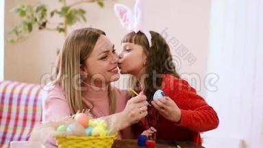 母亲和女儿在复活节前玩得开心，说话，画复活节彩蛋，玩得开心，微笑。