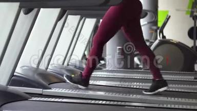 年轻女孩在健身房跑步机上跑步