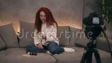 卷曲红头发的年轻女孩vlogger正在互联网上为在线博客拍摄录像