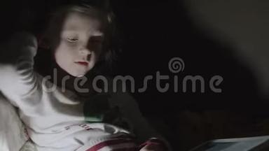 女孩躺在床上，借助灯笼大声朗读。 小女孩躺在床上看书。