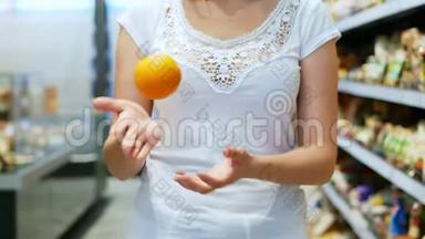 `的女人在超市里用慢动作扔出五颜六色的橘子