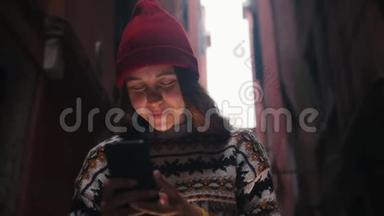 一个女人站在街上，看着手机屏幕。 一道光照亮了她的脸