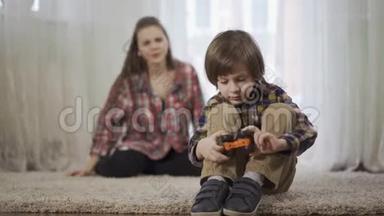 姐姐骂<strong>弟弟</strong>，<strong>弟弟</strong>正在玩玩具车，坐在地上的毛茸茸的地毯上