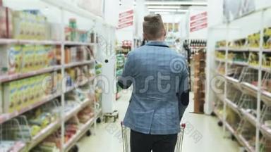 男人在超市购物，打电话，在背面观看，拍摄
