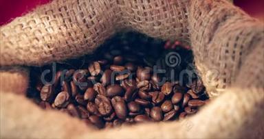 咖啡豆。 女人的手`触摸正在从一袋咖啡中获得咖啡豆。 烤咖啡豆的品质