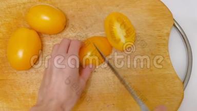 女人在厨房的木板上切<strong>黄番茄</strong>