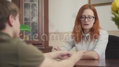 可爱的女心理学家与她的病人会面的肖像。 美丽的红发女心理学家