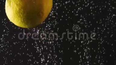 落下来的新鲜黄色柠檬溅到闪闪发光的水在黑色的背景。 宏观射击。 特写镜头。 带视频的