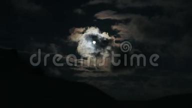 夜晚，云在山上掠过月亮。夜空满月，云彩实时。