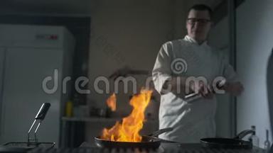 厨师在厨房的热锅上缓慢地点燃火焰，厨房里大明火，锅着火，做饭