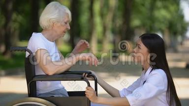 支持坐轮椅的悲伤老年妇女的女志愿者