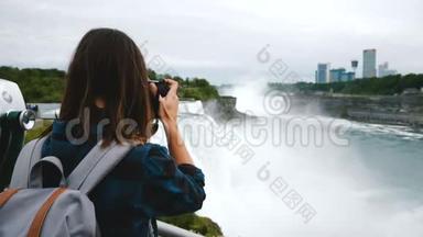 带着背包和相机拍摄史诗尼亚加拉瀑布景慢动作的兴奋旅游妇女的后景。