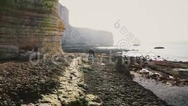 雄蜂在著名的白色诺曼底悬崖上的史诗般的天然岩石拱门中，从年轻快乐的游客新婚夫妇<strong>身边</strong>飞走