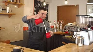 一个男人在一家现代化的<strong>咖啡</strong>店里准备卡布奇诺。 一个人把牛奶<strong>倒</strong>在<strong>咖啡</strong>里。