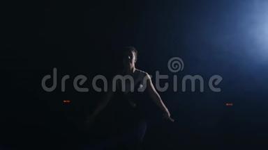 一位年轻的女体操运动员跑过来看着摄像机，向前翻转，在空中慢动作。