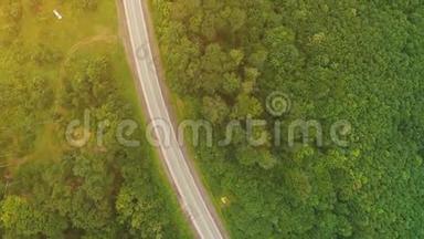 飞越无人机视野.. 一辆白色卡车正沿着高速公路行驶，在山区茂密的森林中。 4K.