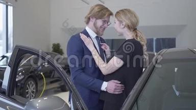 幸福的男人和女人刚刚在现代<strong>车展</strong>上买了车。 一对夫妇在汽车旁拥抱，开着车门