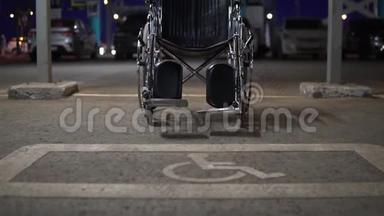 一个空荡荡的轮椅站在一个<strong>残疾人</strong>停车场里。 在附近的人行道上为<strong>残疾人</strong>专用的地方