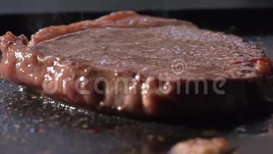 烧烤牛排关闭。 用火钳在烤肉上煮牛肉来翻牛排。 准备食物和烹饪