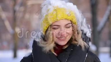 快乐的女人在冬日从头上扔下雪，慢吞吞的