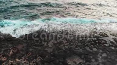 无人机俯瞰海岸，黑色岩石海滩和美丽的巨浪在风暴中撞击悬崖
