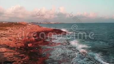 在美丽的粉红色夕阳下，空中无人机可以看到巨大的海浪撞击悬崖