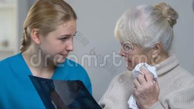 年轻医生给老年妇女看脑x光片并告诉她健康的好消息