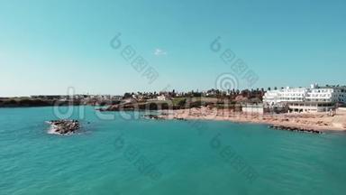 珊瑚湾塞浦路斯航空拍摄与酒店和沙滩和蓝色的水在炎热的晴天。 沙滩无人驾驶飞机与人们一起