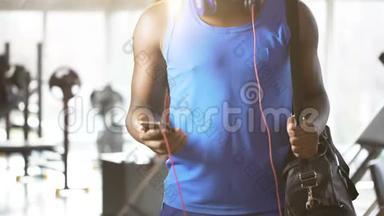 年轻人在健身房里用智能手机听励志音乐跳舞，积极的生活方式