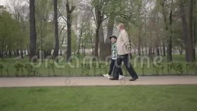 可爱的爷爷和可爱的小孙子一起在公园里散步。 <strong>世代</strong>概念。 友好家庭