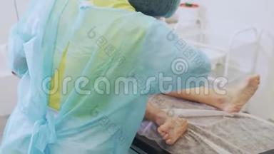 静脉曲张术前消毒病人腿部的无菌衣服护士