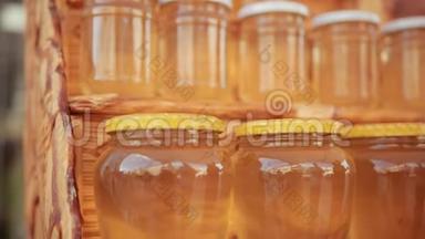 木架上有许多罐蜂蜜，里面有白色和黄色的盖子
