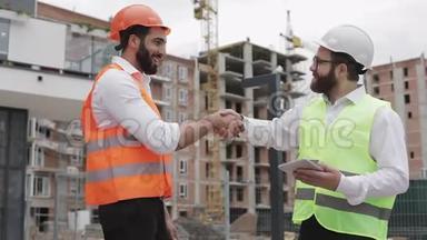 施工经理和工人在施工现场握手.. 专业、建筑、工人、建筑师
