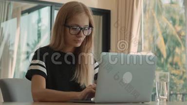 白天，女人在公寓的窗户上<strong>忙着</strong>用笔记本电脑。 自由职业概念