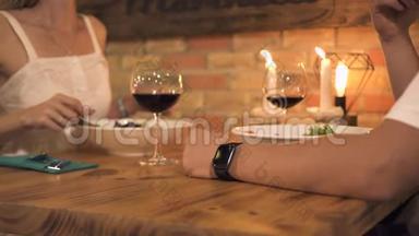 男人和女人在浪漫的晚餐上吃，在优雅的餐厅里有蜡烛。 浪漫的人在浪漫的约会中用餐