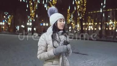 穿着温暖衣服的女孩，在冬天的广场上喝杯咖啡。