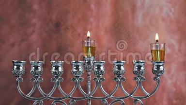 在光明节上点燃第一支蜡烛在燃烧的光明节烛台上点燃第一支蜡烛，蜡烛是米诺拉