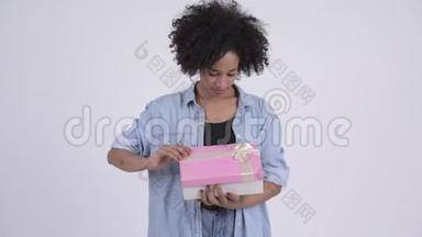 年轻快乐的非洲女人<strong>打开礼物盒</strong>，看上去很惊讶